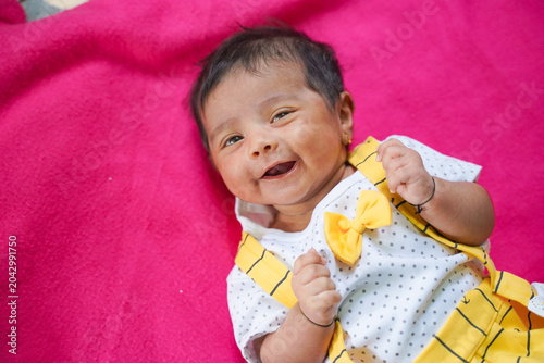 Schilderij op canvas cute indian baby girl laying on pink soft cloth