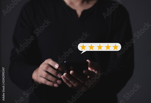 Customer Review, Young Man hand holding Smart Phone with five star to review and give 5 stars with very good results in service, Good review 5 star rating choice feedback