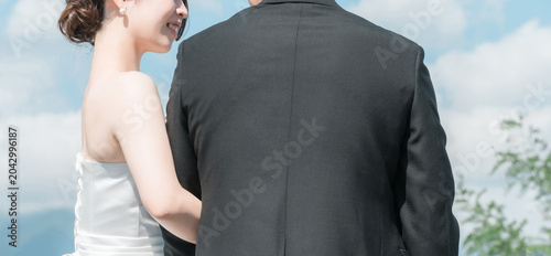 Obraz na plátně A couple with their arms linked, the bride and groom's backs, and their profiles during a wedding photoshoot