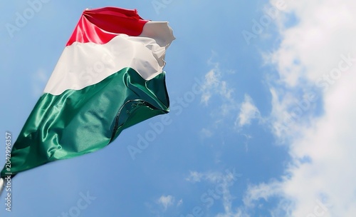 Photos Photo of a Hungarian flag fluttering in the wind, with a blue sky, a few white clouds on the right, and plenty of copy space