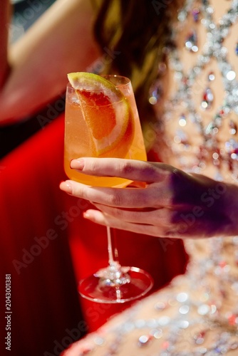 Foto Elegant Woman Holding Citrus Cocktail at Luxury Event