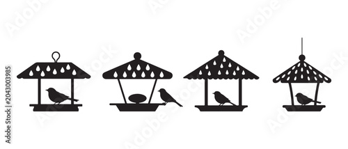 Tableau sur toile Set of black silhouette icons of small birds sitting on wooden bird feeders in the garden