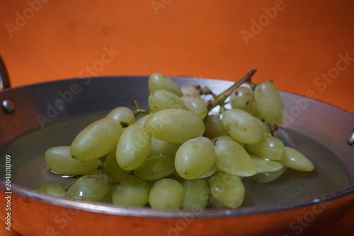 Fresh green grapes hanging in clusters, juicy, nutritious, naturally sweet, and refreshing fruit.
