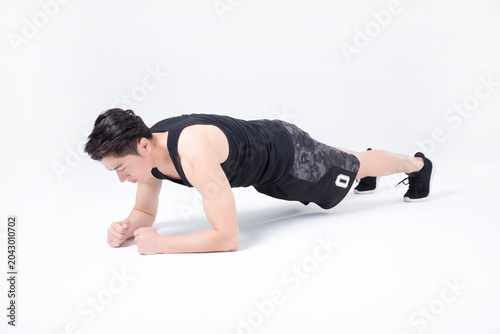 фотографія Young man doing forearm plank exercise in studio