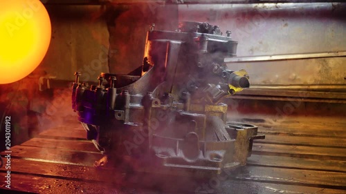 cleaning and washing with a steam cleaner of an old manual transmission from a front-wheel drive car for repair evening video shooting with red and purple lighting