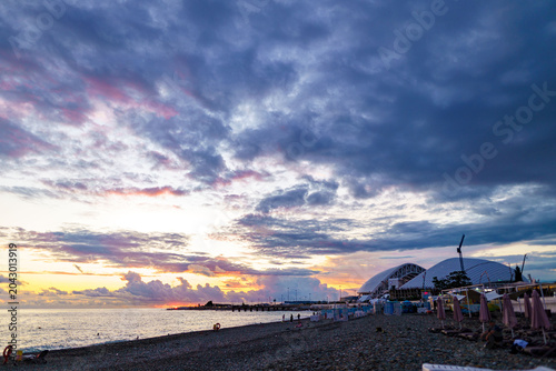 cenic shot of sea under dark dramatic clouds during bright sunset