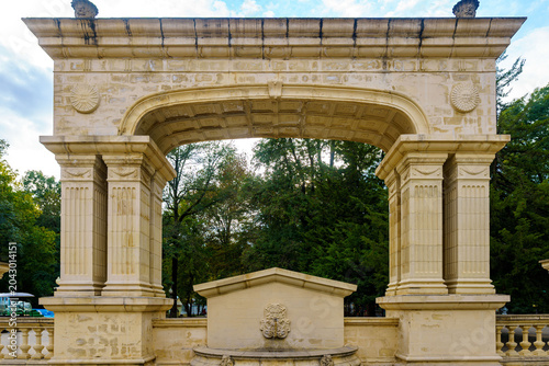 Fényképezés Symmetrical shot of an ancient stone triumphal arch in park