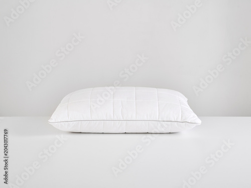 Single white pillow isolated on white background, minimal clean composition emphasizing softness, comfort, hygiene, and modern bedding product presentation with simple, elegant aesthetic style.