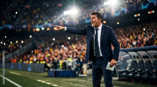 Professional football manager shouting and gesturing tactics from sidelines during match