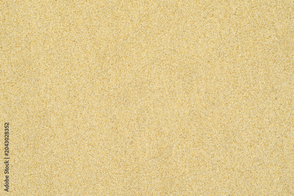 Fototapeta premium Beach sand background texture – top view of seamless flat sand surface. Brightly lit and sunny. Image is ready to be tiled to create a much larger image or higher resolution background.