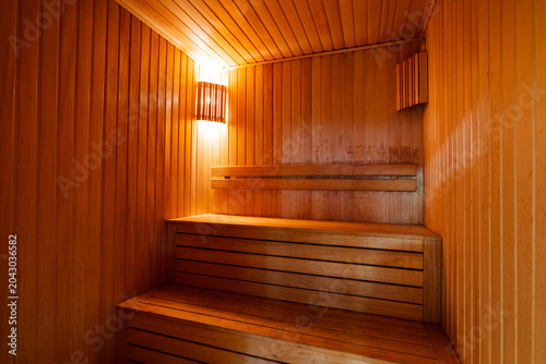 Fotografie Cozy wooden sauna interior with benches and warm light