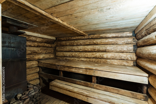 Photos Rustic wooden sauna interior with log walls and built-in benches
