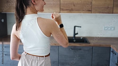 Young woman standing in modern apartment kitchen and holding house keys. Female home ownership and independent real estate investment concept