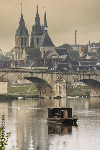 Tableau sur toile Golden morning light bathes the ancient church with towering spires, reflecting off the calm river