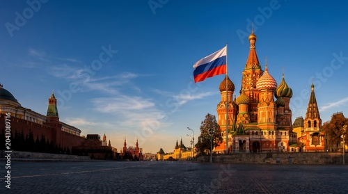 Saint Basils Cathedral and Russian flag on Red Square during golden hour sunset in Moscow