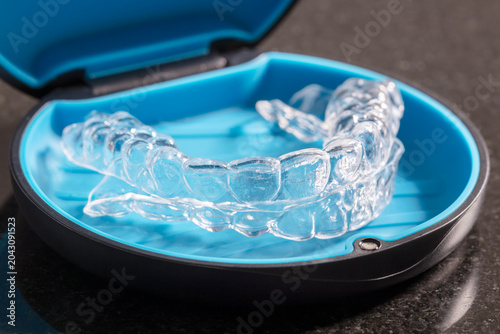 Transparent orthodontic retainers or braces in a box container