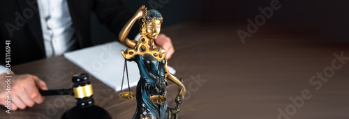 Fotografie A judge’s gavel, scales of justice, and judge writing documents, representing law, authority, rulings, and courtroom proceedings