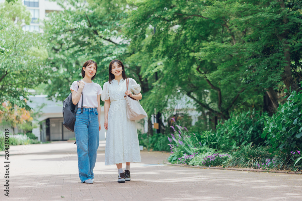 Obraz premium 大学のキャンパスを歩く女子大生二人組