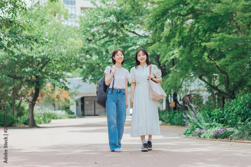 Obraz premium 大学のキャンパスを歩く女子大生二人組