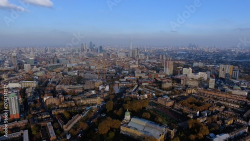 фотографія 4K aerial drone view of the London skyline featuring the Imperial War Museum, The Shard, and the City financial district under a clear blue sky
