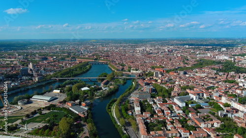 4K aerial drone image of Toulouse, France. Panoramic summer cityscape featuring the River Garonne and historic red brick architecture.