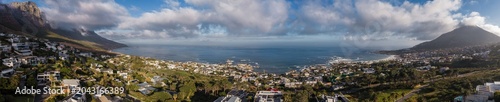 Foto Aerial view of Cape Town Atlantic Seaboard shows suburbs on green hills, Twelve Apostles by Camps Bay, Lion's Head at right, calm steel blue ocean, late afternoon light