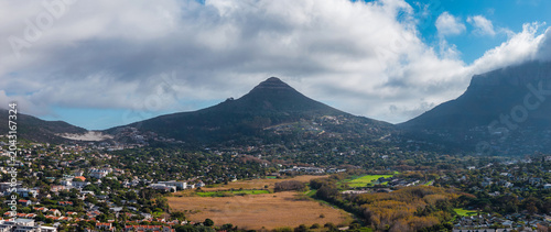 Photos Lion's Head stands centered under drifting clouds, Table Mountain looms right