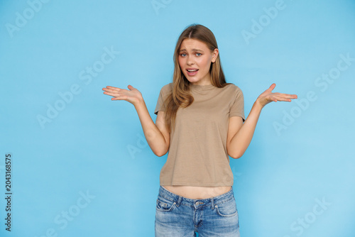 Young woman confused isolated on blue background