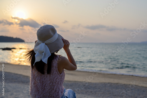 Foto 沖縄の夕焼けを眺める日本人女性の後ろ姿