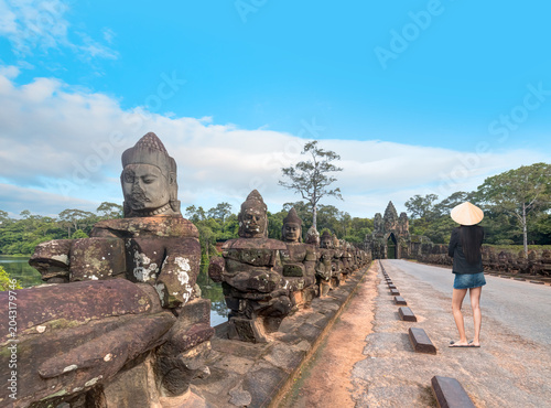 Photos A beautiful Southeast Asian woman inspects a historical structure wearing a coni
