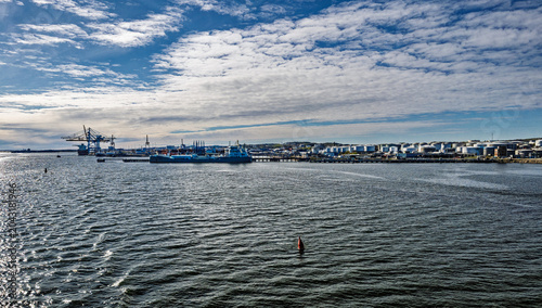 Cargo Ship and Container Cranes at Busy Industrial Port Under Blue Sky and Calm Water, Gothenburg, Sweden