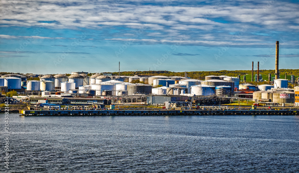 Naklejka premium Oil Refinery Storage Tanks and Industrial Waterfront Terminal Along Harbor With Shipping Infrastructure, Gothenburg, Sweden
