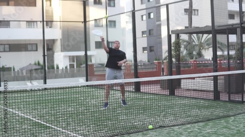 Slow motion, man playing padel tennis at the net