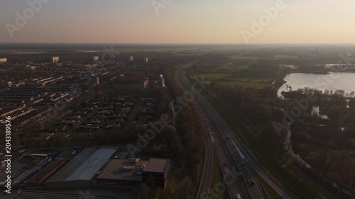 Wide aerial view of Dutch town, highway and landscape at Golden Hour