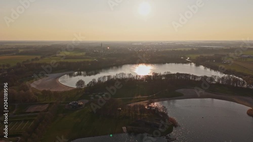 Wide aerial approach over Engelenmeer lake near Vlijmen at Golden Hour