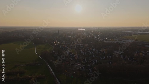 Wide aerial approach toward Vlijmen town and countryside at Golden Hour