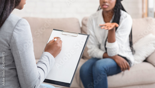 Obraz na plátně Psychologist having therapy session with her patient in office, listening proble