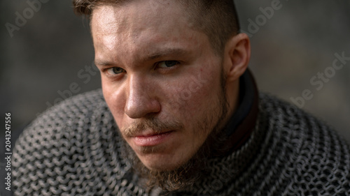Foto Intense gaze of a rugged man wearing chainmail, hinting at strength and resilience