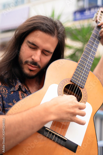 Passionate Flamenco Guitarist Playing with Eyes Closed in Emotional Performance
