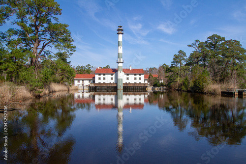 Fotografija The historic Lake Mattamuskeet pumping station and former hunting lodge stand reflected in calm waters, showcasing a unique landmark within North Carolina’s coastal wetlands