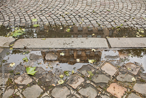 An urban image in Paris, with a reflection in a puddle