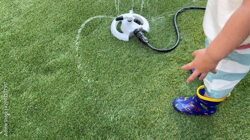 芝生で水遊びする子供