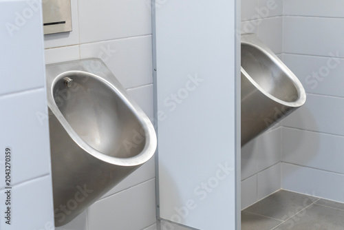 Urinals in a gray tiled public toilet