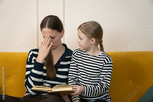 Картината върху платно Frustrated mother experiencing stress and headache while helping her young daugh