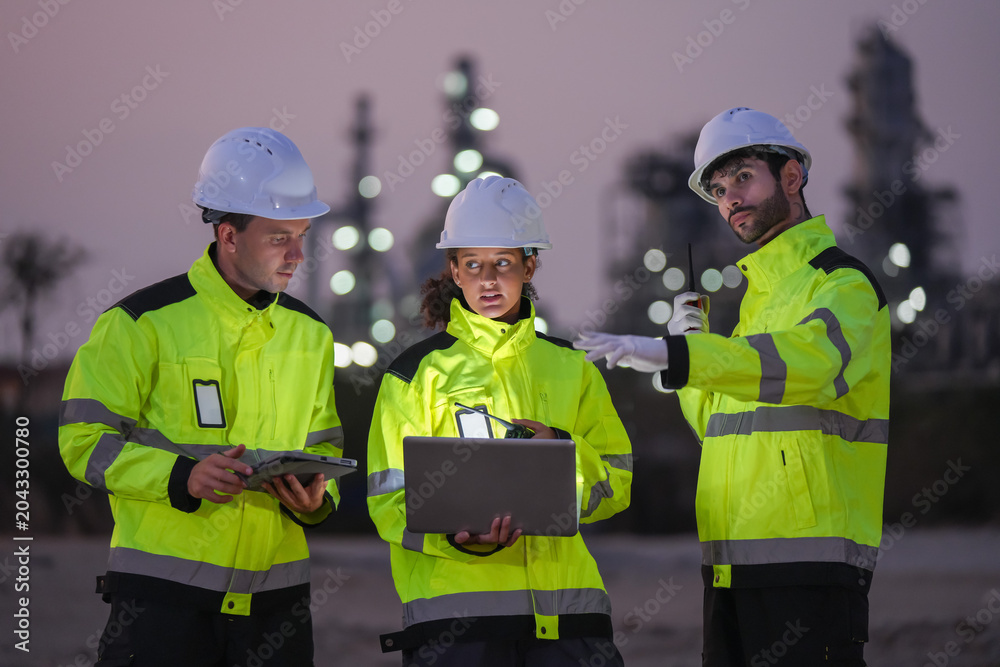 Fototapeta premium Collaborative safety briefing among engineers at industrial site nighttime professional meeting urban environment close-up teamwork
