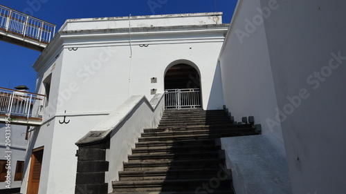 Foto A beautiful stone staircase leads to the second floor of a white building attached to the boundary wall