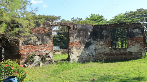 Bild auf Leinwand A wall made of red brick with a damaged coating is located at Van den Bosch Fort, Ngawi, East Java, Indonesia