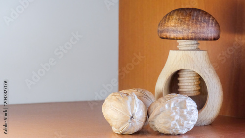 Walnuts and a nutcracker on a wooden floor, with a copy space on the left