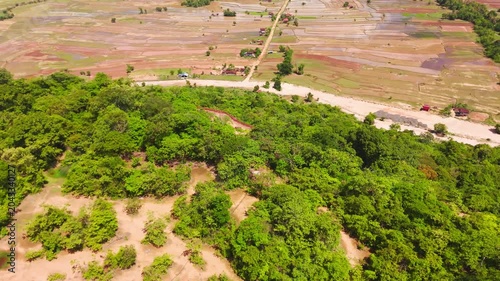 Vertical aerial footage near Khamtay Cave, Attapeu Province, Laos. The portrait format drone video captures the distinctive flat-top mesa and the agricultural valley below in a cinematic vertical comp