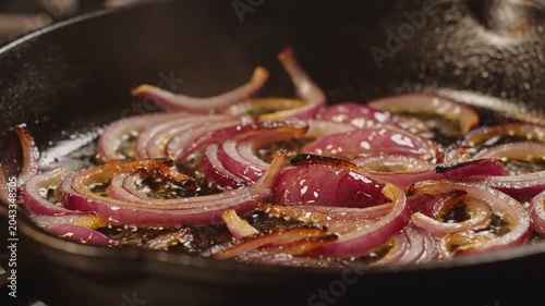 Red Onion Slices Frying in Cast Iron Skillet